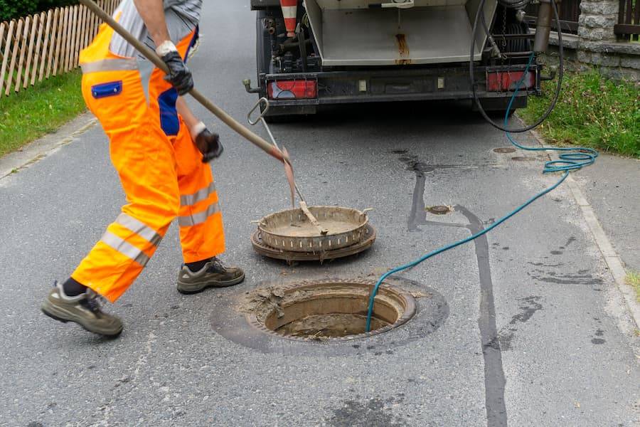 Blocked Drains plumber carrying out blocked drain clearing in London